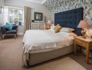 a bedroom with a large bed with a blue headboard at Buccleuch Arms in Saint Boswells