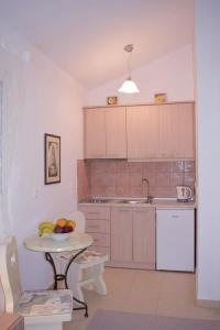 a kitchen with a table with a bowl of fruit on it at Irida Cottage in Vlachopoulátika