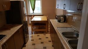 a small kitchen with a sink and a table at Hostel Poznań Petit in Poznań