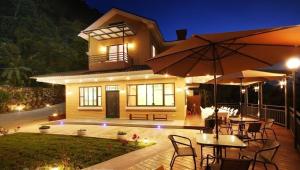 a house with tables and umbrellas on a deck at Sunlight Forest in Dahu