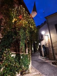 un edificio ricoperto di edera con luci su una strada di "Il Nido" a Sermoneta