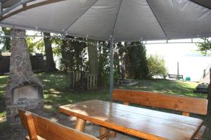a wooden bench under an umbrella in a yard at Ferienhof Löschebrand in Bad Saarow +1 photo