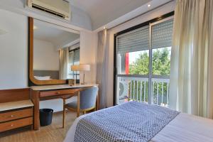 a bedroom with a desk and a bed and a window at Gran Hotel Parana in Paraná