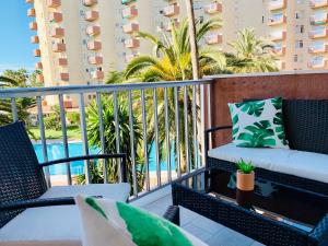 balcón con sillas y piscina en Apartamento Góndolas, en Almuñécar