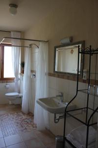een badkamer met een wastafel, een toilet en een spiegel bij Ferienwohnung zur Burg Eltz in Wierschem