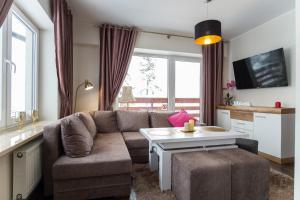 a living room with a couch and a table at Apartamenty Ciche Wzgórze Zakopane in Zakopane