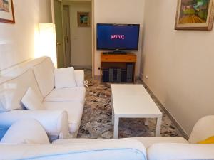 un soggiorno con divani bianchi e TV di Bari Grand Central Apartment a Bari