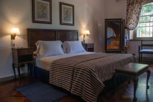 1 dormitorio con 1 cama grande con manta a rayas en Boutique Hotel Sevilla en La Cumbre
