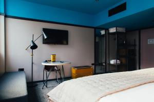 a bedroom with a bed and a tv on a wall at Bullitt Hotel in Belfast