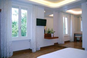 a bedroom with a bed and a tv and windows at B&B Romeo in Santarcangelo di Romagna