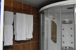 a bathroom with a shower and white towels at Golden Royale Hotel in Enugu