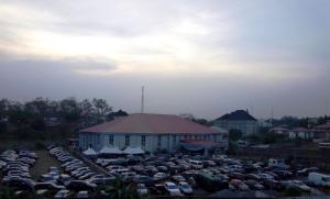 a parking lot full of cars in front of a building at Golden Royale Hotel in Enugu