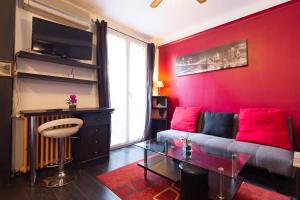 a living room with a couch and a red wall at le stud in Golfe-Juan