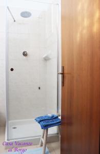 a shower with a blue towel on a stool in a bathroom at Casa Vacanze Al Borgo in Caprino Veronese