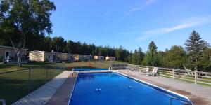 a swimming pool in a yard with a fence at Millstream Cottages in Brackley Beach