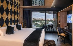 a hotel room with a bed and a view of a city at H Hotel & SPA - Adults Only in St. Julianʼs