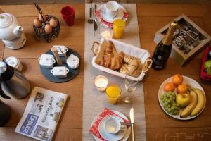 een tafel met ontbijtproducten en een fles champagne bij De Loteling in Zoersel