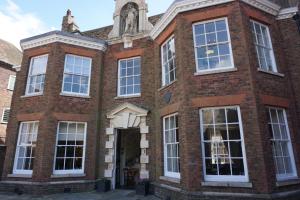 a brick building with white windows and a tower at Bank House in Kings Lynn