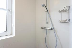 a bathroom with a shower stall and a toilet at Buitenplaats Witte Raaf aan Zee in Noordwijk
