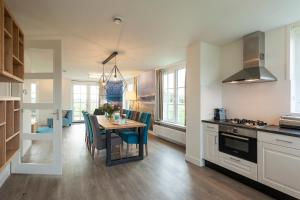 a kitchen and dining room with a table and chairs at Buitenplaats Witte Raaf aan Zee in Noordwijk