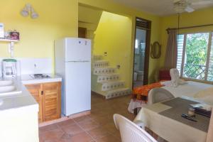 a kitchen with a white refrigerator in a room at Sea Hawk Suites in Isla Mujeres