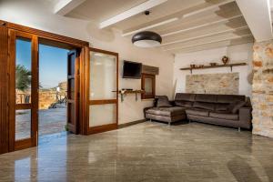 a living room with a couch and a television at Villa Thalia in Castellammare del Golfo