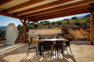 a table and chairs on a patio with a view at Villa Thalia in Castellammare del Golfo