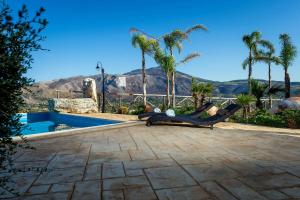 a resort with a swimming pool and palm trees at Villa Thalia in Castellammare del Golfo