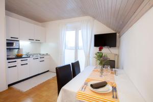 eine Küche und ein Esszimmer mit einem Tisch und Stühlen in der Unterkunft Apartments Special Bled in Bled