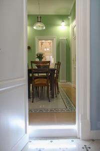 a dining room with green walls and a table and chairs at Casa Pinello in Palermo