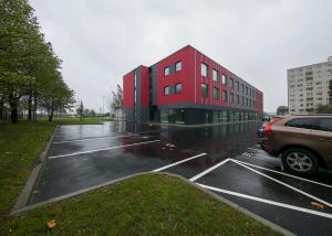 a red building in a parking lot in the rain at LKS Apartment 3 in Tallinn