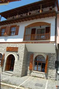 Casa con puertas de madera y balcón. en Hotel Berati, en Berat