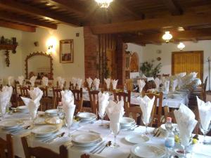 a dining room with tables with white plates and napkins at Kéktó Kemping in Gyékényes