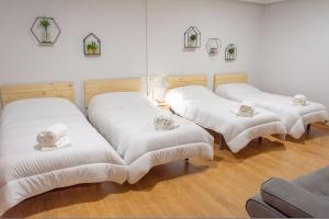 a group of white beds in a room at Toledo Mágico in Madridejos