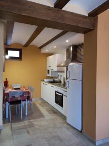 eine Küche mit einem Tisch und einem weißen Kühlschrank in der Unterkunft Casa rural Abascal in Cella