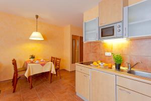 une cuisine et une salle à manger avec une table et une cuisine gmaxwell gmaxwell dans l'établissement Strandvilla Alessandra, à Trassenheide