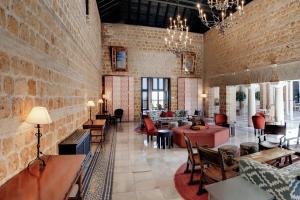 a large room with a brick wall and tables and chairs at Parador de Carmona in Carmona