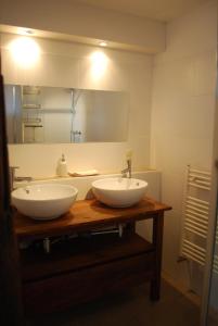 a bathroom with two white sinks and a mirror at Unter Eichen in Uplengen