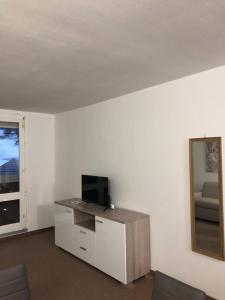sala de estar con TV y espejo en Appartamento San Nicola 2 secondo piano, en San Massimo