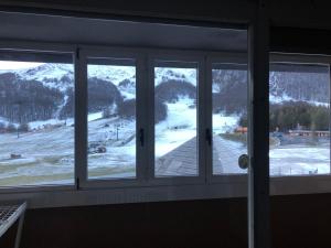 una ventana con vistas a una montaña nevada en Appartamento San Nicola 2 secondo piano, en San Massimo