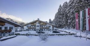 ein großes Gebäude im Schnee mit schneebedeckten Bäumen in der Unterkunft Alpensuite TOP 6 am Wilden Kaiser in Scheffau am Wilden Kaiser