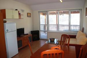 a kitchen and living room with a table and a refrigerator at Eagle Rock View Apartment, Borovets in Beli Iskar