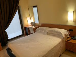 una camera d'albergo con due letti e due finestre di Best Western Hotel Class Lamezia a Lamezia Terme