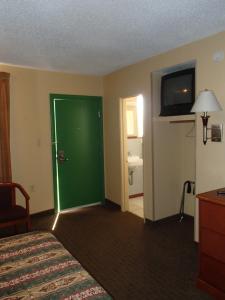 a hotel room with a green door and a bathroom at Royal Inn Of New Orleans in New Orleans