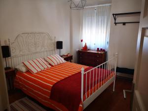 1 dormitorio con 1 cama con colcha de color naranja y blanco en Cardal Apartment en Lisboa