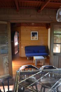 uma sala de estar com um sofá azul e uma mesa em Chalet Y Cabinas Hibiscus em Cahuita