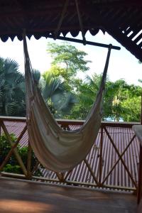 a hammock on a fence with palm trees in the background at Chalet Y Cabinas Hibiscus in Cahuita