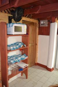 a kitchen with a microwave and a refrigerator at Chalet Y Cabinas Hibiscus in Cahuita