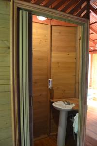 a bathroom with a sink and a wooden wall at Chalet Y Cabinas Hibiscus in Cahuita