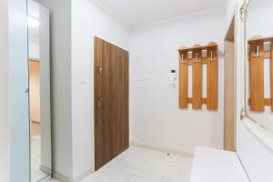 a bathroom with a wooden door and white walls at Apartament z widokiem na rzekę Gdańsk Stare Miasto in Gdańsk